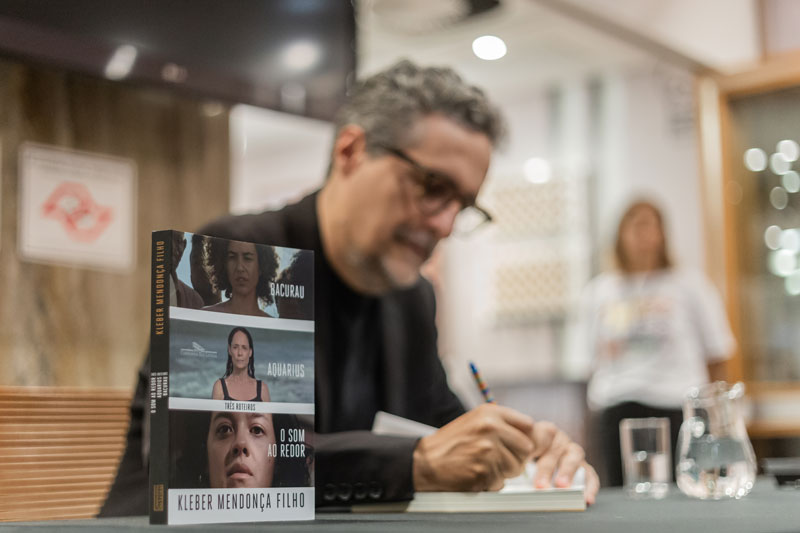 Kleber Mendonça Filho autografa exemplares do livro "Três Roteiros" no CineSesc durante o 49ºFestival Sesc Melhores Filmes. 